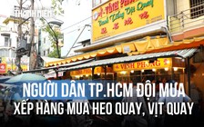 Người dân TP.HCM đội mưa xếp hàng mua heo quay, vịt quay ngày vía Thần tài