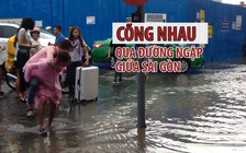 Các cô gái Hàn Quốc cõng nhau qua đường ngập ở trung tâm Sài Gòn