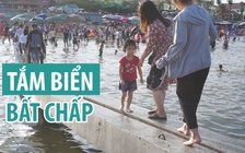 Du khách mạo hiểm tắm biển bên công trình cầu cảng đang thi công