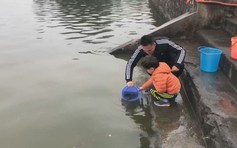Người Hà Nội dẫn trẻ nhỏ đi thả cá cúng ông Táo