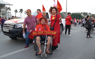 Cổ động viên ngồi xe lăn được vợ ‘hộ tống’ đi cổ vũ đội tuyển Việt Nam
