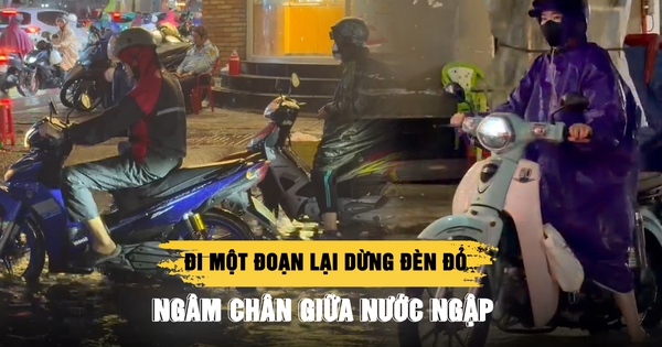 Mưa lớn giờ cao điểm ở TP.HCM: Đi một đoạn lại dừng đèn đỏ, ngâm chân giữa nước ngập